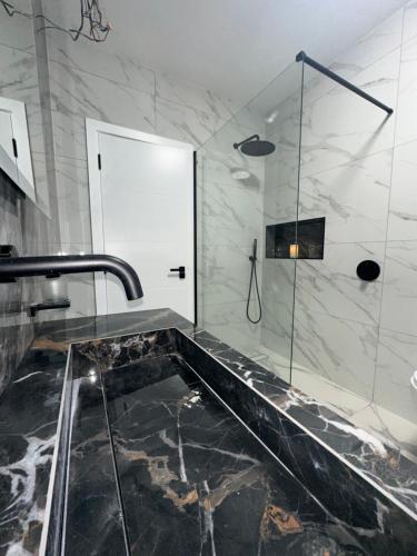 a bathroom with a walk in shower and a sink at Luxurious & Elegant 6-Bed House in Barnet