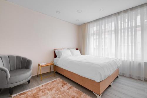 1 dormitorio con 1 cama, 1 silla y 1 ventana en Cozy Flat 10 min to Marmaray and Uskudar Coast, en Estambul