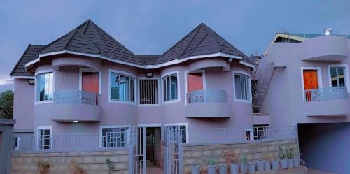a large pink house with a roof at OLENG'OTI GARDENS in Narok