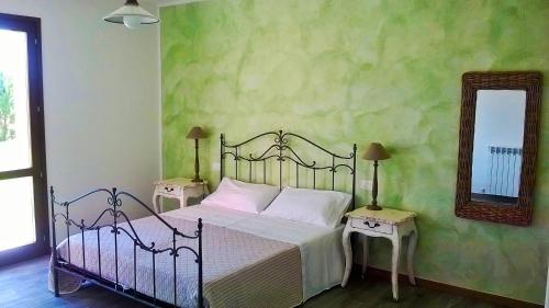 a bedroom with a bed with two tables and a mirror at Agriturismo Rossococomero colazione inclusa e Offerta PROMO LUGLIO! in Sirolo