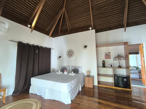 a bedroom with a white bed and a television at U Story Resort in Siquijor