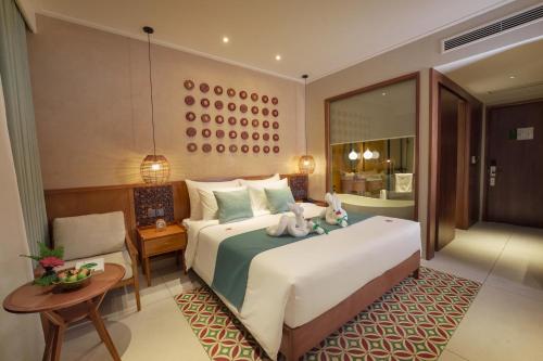 a bedroom with a large bed and a table at Little Gem. An Eco-Friendly Boutique Hotel & Spa in Hoi An