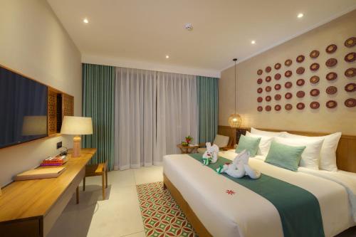 Habitación de hotel con 2 camas y escritorio en Little Gem. An Eco-Friendly Boutique Hotel & Spa en Hoi An