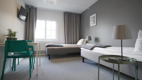 ein Schlafzimmer mit einem Bett, einem Tisch und einem Stuhl in der Unterkunft Forenom Hostel Gothenburg Säve in Göteborg