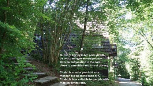 a sign in the middle of a forest with trees at Chalet Durbuy 123 in Durbuy