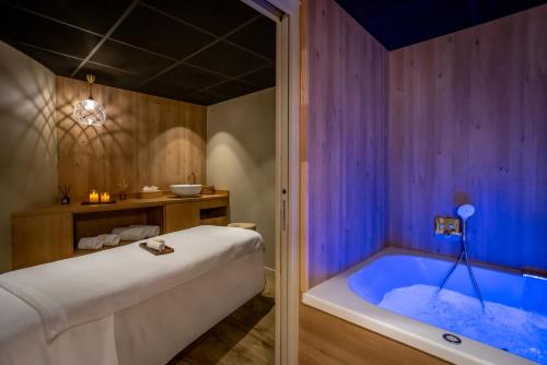 ヴァンヌにあるHôtel & Spa Le Maury, Vannes, The Originals Boutiqueのバスルーム(大型バスタブ付)が備わります。