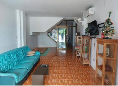 a living room with a blue couch and a staircase at Classic Home Stay Hatyai in Ban Tha Sae