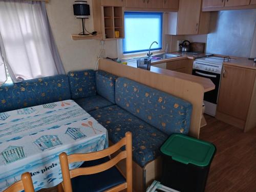 a kitchen with a couch and a table in a kitchen at Mobil home L42 in Le Portel