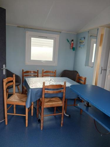 une salle à manger avec une table et des chaises bleues dans l'établissement Mobil home L42, à Le Portel