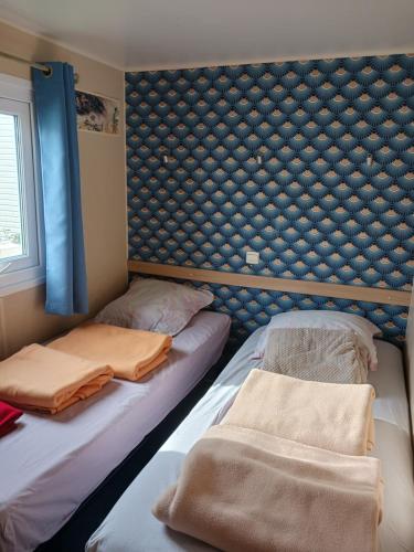 two beds in a room with a wall at Mobil home L42 in Le Portel