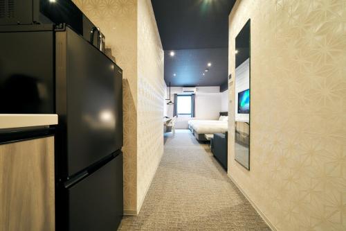 a hallway leading to a bedroom with a bed in a room at Rakuten STAY Kokura Station in Kitakyushu