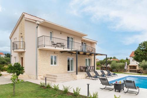 een villa met een zwembad en een huis bij Villa Oliva - Adriatic Luxury Villas in Murvica