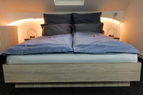 un grand lit avec des oreillers bleus dessus dans l'établissement Transylvanian Hideaway Apartment, à Sibiu