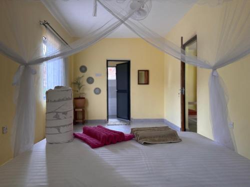 a bedroom with a white bed with a canopy at Karibu Africa Home in Moshi