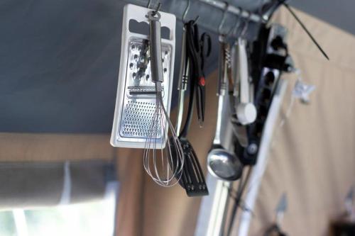 a kitchen utensils are hanging on a wall at Europe tents Camping Gritt in Diekirch
