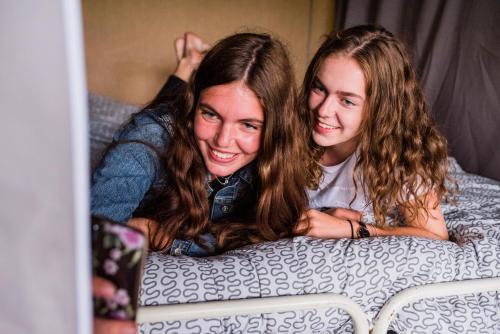 two young women laying on a bed at Europe tents Camping Gritt in Diekirch