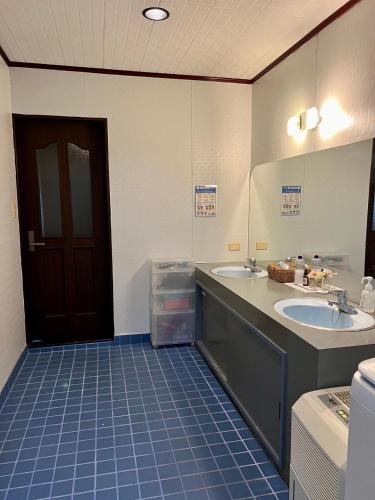 baño con 2 lavabos y puerta marrón en 百合ヶ浜ビーチハウス, en Furusato