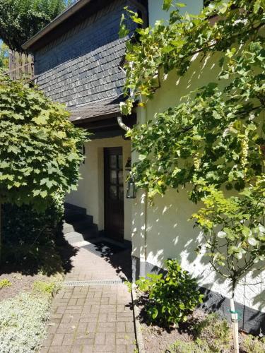 a white house with a door and some trees at Ferienhaus In der Hohl in Cochem