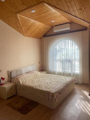 a bedroom with a large bed and a window at Villa near SeaBreeze Nardaran Baku in Baku
