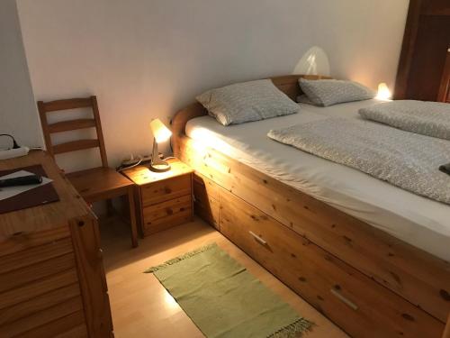 a bedroom with a bed and a desk with a lamp at Pension Deinhardt in Hirschaid