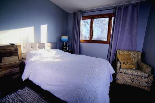 a bedroom with a bed and a chair and a window at Quiet And Comfortable Deluxe in Anchorage