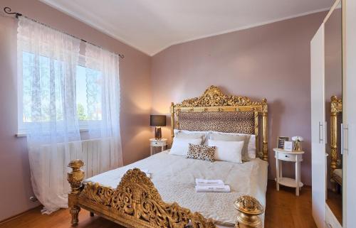 een slaapkamer met een groot bed met een gouden bedframe bij Family House SEA MARE I in Pula
