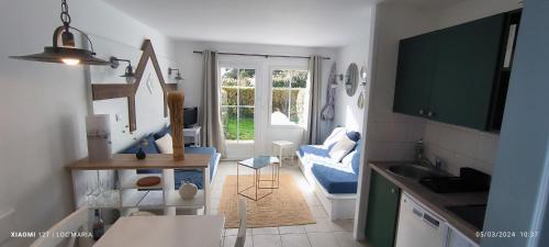 uma cozinha com um lavatório e um sofá azul num quarto em Location LOC'MARIA - Résidence Marie-Galante - Location Professionnelle em Locmaria