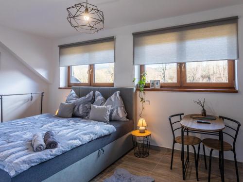 1 dormitorio con cama, mesa y ventanas en Penzion Krumlovské rozcestí, en Český Krumlov