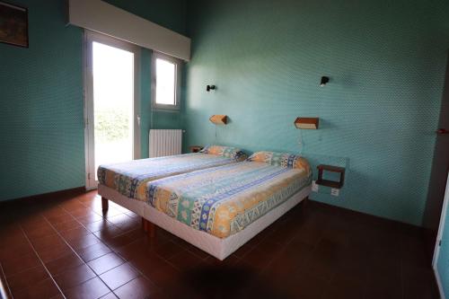 sypialnia z łóżkiem w pokoju z zielonymi ścianami w obiekcie Canet en Roussillon belle maison de vacances w mieście Canet-en-Roussillon