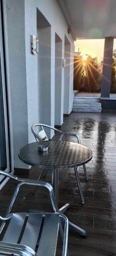 a table and chairs on a patio with the sunset at TOPAZ four in Siviri