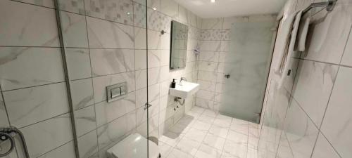 a white bathroom with a shower and a sink at TOPAZ four in Siviri