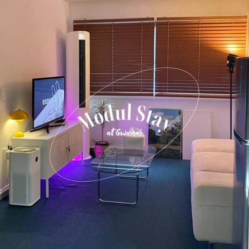 a room with a desk with a television and a couch at Modeul Stay in Seoul