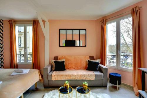 a living room with a couch and a bed at 145 Suite Marco - Superbe Appartement à Paris in Paris