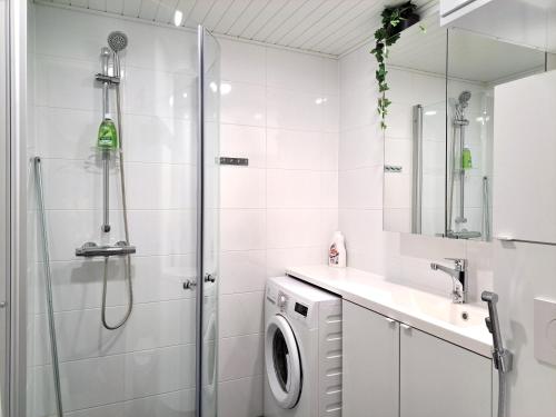 y baño con ducha y lavadora. en Kotimaailma Apartments - moderni keskustayksiö - Aleksanterinkatu, en Tampere
