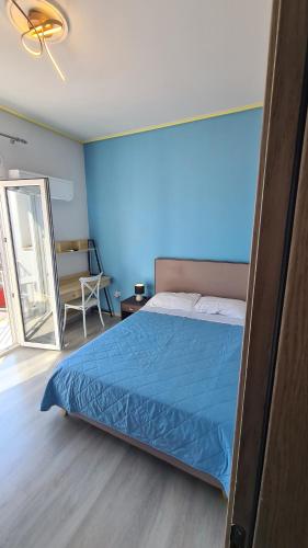 a bedroom with a bed and a blue wall at ΛΙΜΑΝΙ in Chios