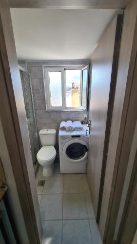 a small bathroom with a toilet and a washing machine at ΛΙΜΑΝΙ in Chios