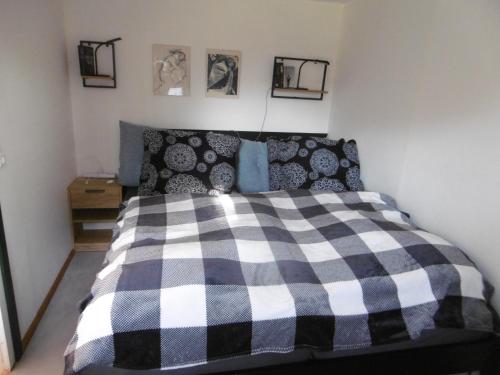 a bedroom with a black and white checkered bed at Ferienbungalow Am Birkenwäldchen in Kolonie Röntgental