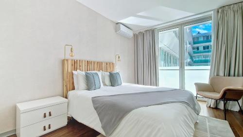 フンシャルにあるUpscales by LovelyStay - private parkingの白いベッドルーム(ベッド1台、大きな窓付)