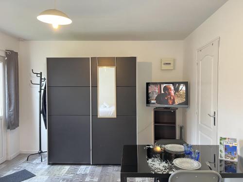 - un salon avec un réfrigérateur noir et une télévision dans l'établissement Le Vinci 3, à Calais