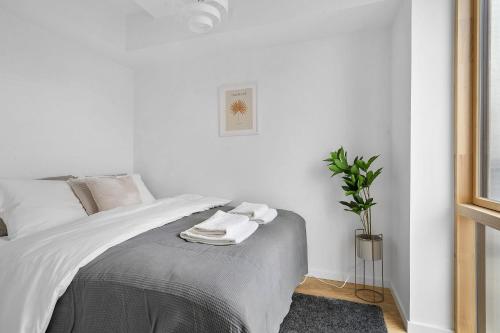 a white bedroom with a bed with towels on it at Little luxury apartment in Aarhus