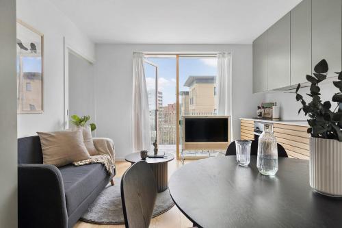 a living room with a table and a couch at Little luxury apartment in Aarhus