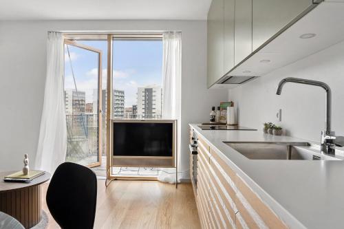 a kitchen with a television and a large window at Little luxury apartment in Aarhus