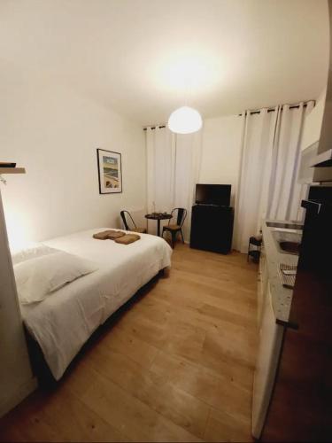 um quarto com uma cama e uma mesa com uma cadeira em Le 29 cuty, wifi, à 3min de la gare sncf em Agen