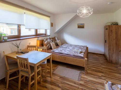a living room with a bed and a table at Penzion Krumlovské rozcestí in Český Krumlov