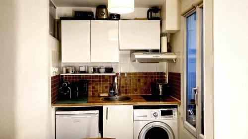 una piccola cucina con lavandino e lavatrice di OlympicParis a Parigi