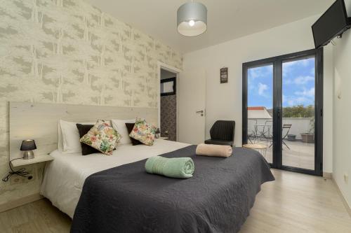 um quarto com uma cama grande e uma varanda em Casa do Vale Cabo em Olival