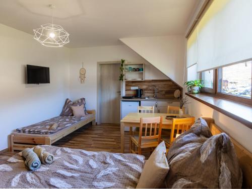 a living room with a bed and a dining room at Penzion Krumlovské rozcestí in Český Krumlov