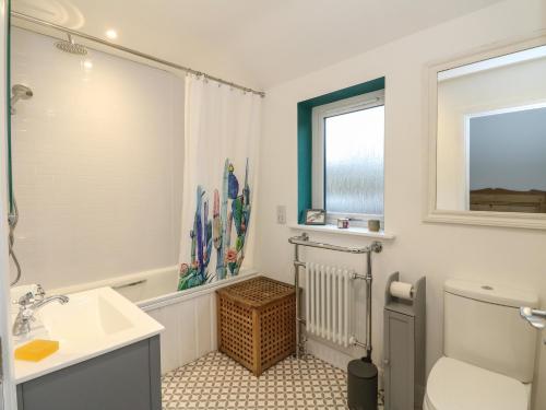 baño con lavabo y aseo y ventana en The Pier House en Lochgilphead