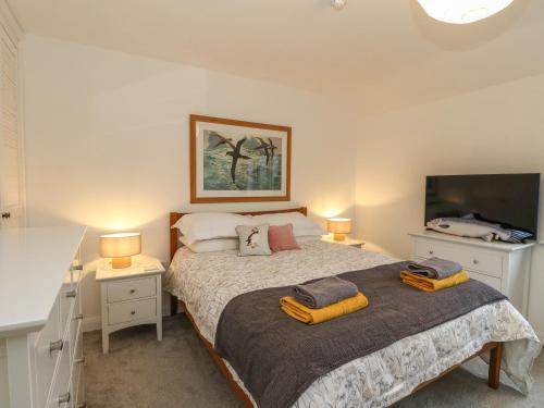 1 dormitorio con 1 cama con 2 lámparas y TV en The Pier House en Lochgilphead