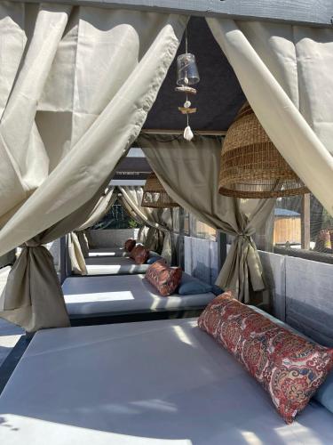 a group of beds in a room with curtains and pillows at BOHO HOUSE in Ustrzyki Dolne